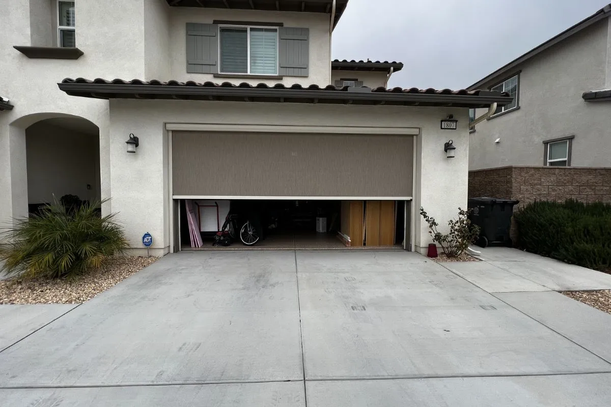 Home gym in garage with retractable garage screen providing ventilation and privacy